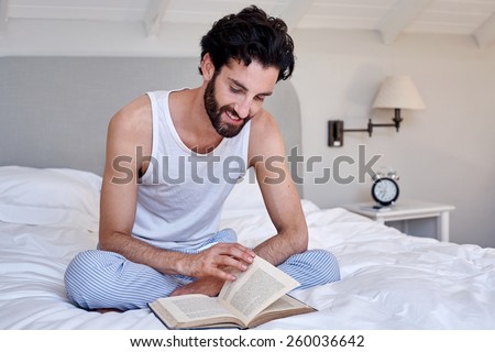 man relaxing on bed reading literature novel story book at home