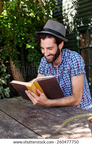 young man relaxing outdoors reading literature novel story book at home
