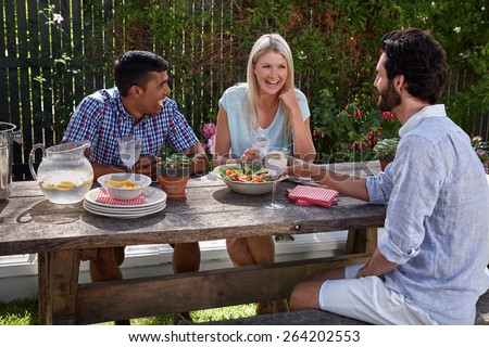 group of friends having outdoor garden cocktail dinner party