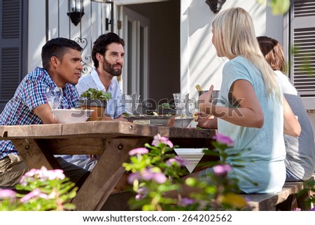 group of friends having outdoor garden dinner party