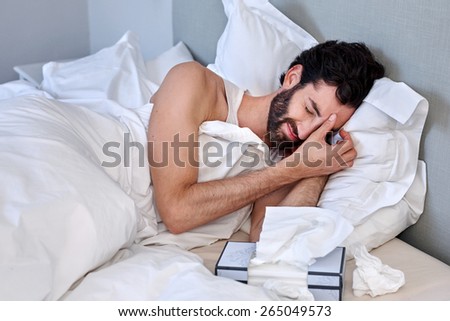 depressed sad sick man with tissues in bed at home