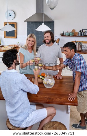 Group of friends cheers toasting in kitchen