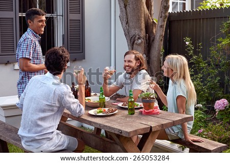 man toasting speech at friends outdoor garden party with wine drinks