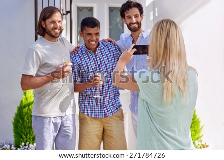 women taking photo pictures of group friends on mobile cellphone camera outdoors at garden party