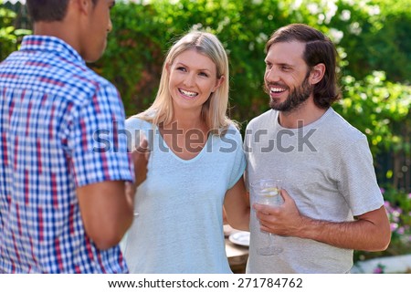 friends chatting outdoors at garden party gathering with cocktail wine drinks