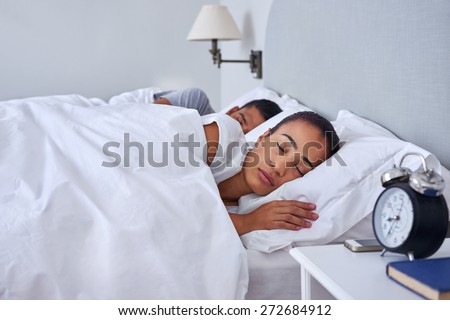 peaceful young couple sleeping comfortably in bed at home