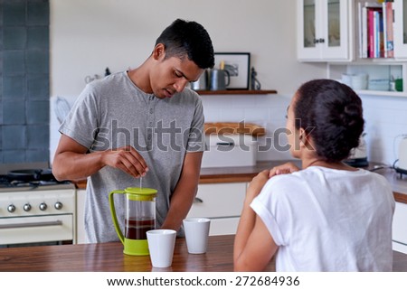 couple relaxing with coffee in home kitchen