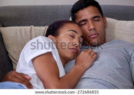portrait of romantic married couple sleeping on sofa couch in home living room