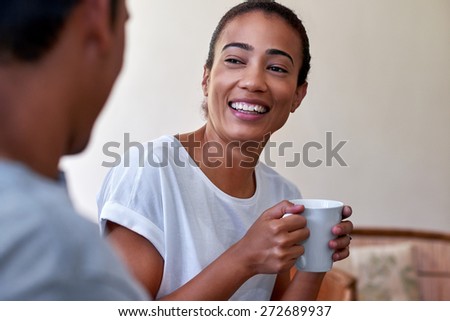 young couple relaxing on sofa couch with morning coffee mug in love
