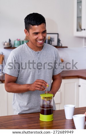 man preparing french press plunger coffee for early morning routine in kitchen