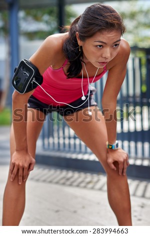 exhausted sporty asian chinese woman runner after fitness running workout outdoors