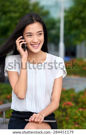 asian chinese businesswoman office worker communicating with mobile phone on coffee break outdoors