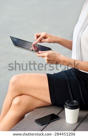 businesswoman office worker communicating with tablet computer on coffee break outdoors