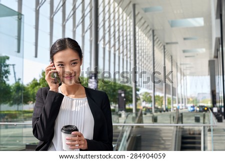 asian chinese businesswoman office worker communicating with mobile phone on coffee break