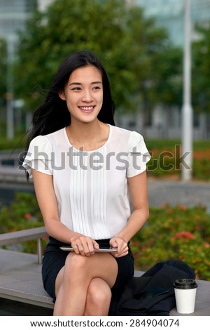 asian chinese businesswoman office worker communicating with tablet computer on coffee break outdoors
