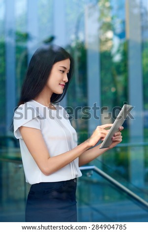 asian chinese business woman working on tablet computer in modern office