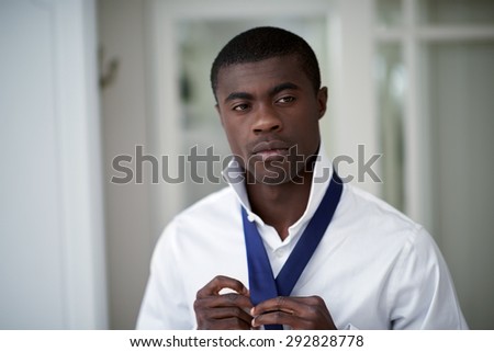 handsome professional african black man getting ready morning routine shirt and tie at home for work