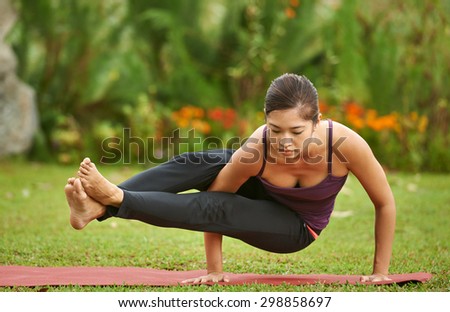 strong yoga woman practice routine in park doing Astavakrasana pose