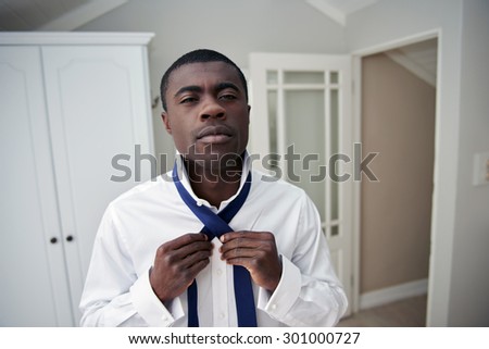 handsome professional african black man getting ready morning routine shirt and tie at home for work