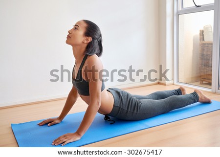 young fitness female practicing a yoga pose, position indoors