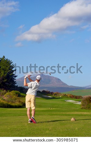golfer hitting driver off tee box on a beautiful scenic course