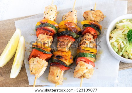 Light summer lunch grilled chicken and vegetable skewers served with coleslaw side salad