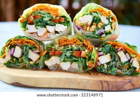 Cross section of healthy vegetable wraps with carrots, greens and chicken