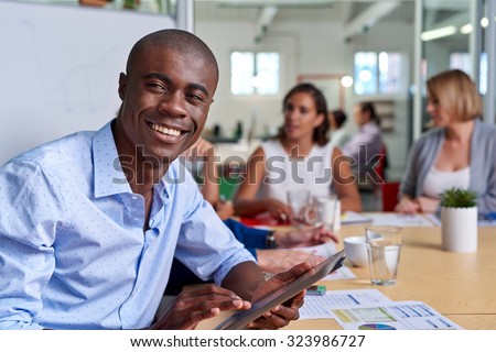 portrait of professional african black business man during coworkers boardroom meeting with tablet computer taking notes