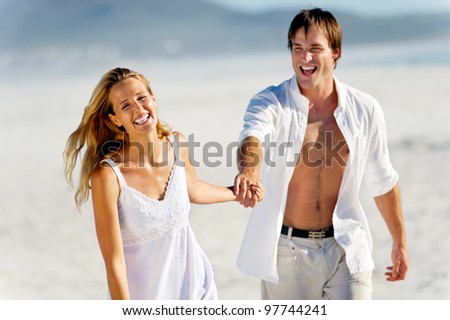 romantic honeymoon couple walk on the beach during a tropical summer holiday vacation. carefree stress free lifestyle concept.
