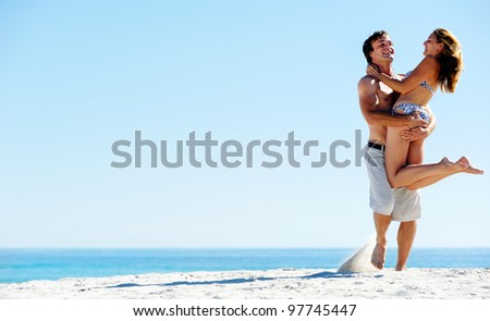 Happy couple playing on the beach, summer spin and hug embrace
