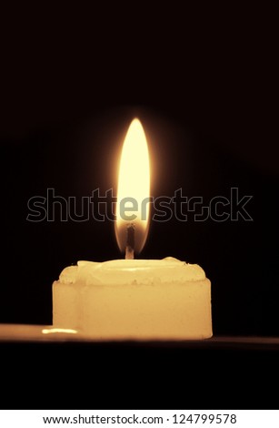 White candles, on a black background, dazzling flashing light.