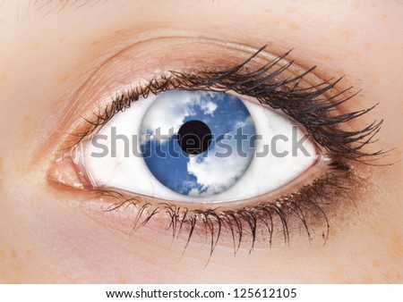 surrealistic picture of a woman\'s  eye with the sky in it
