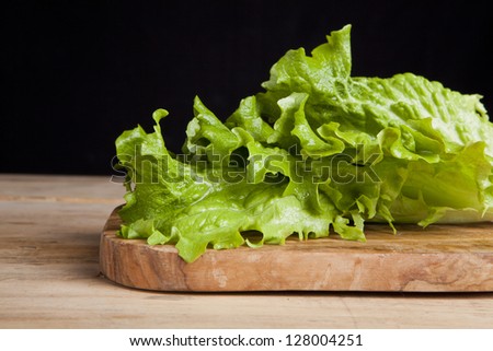 lettuce leaf on cutting board on black background