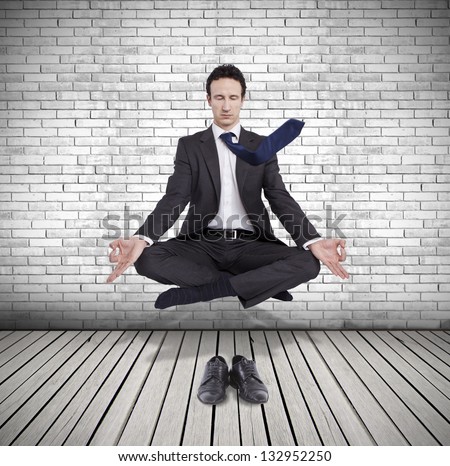 young businessman levitating in yoga position, meditation