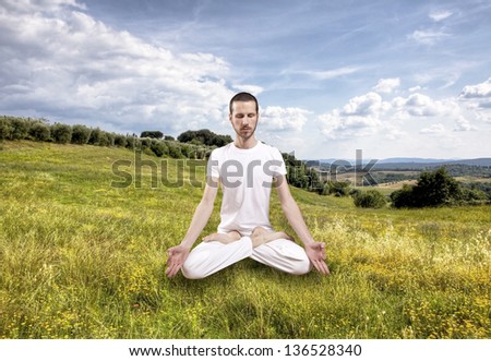young man practicing yoga outdoor, lotus position