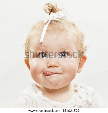 Portrait Of An Adorable Baby Girl With Tongue Sticking Out