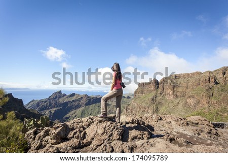 young woman on top of a mountain enjoying the view