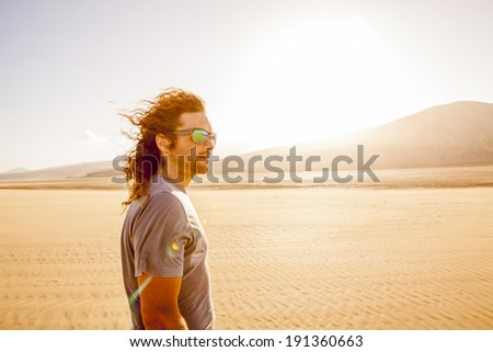 young man portrait in the desert during sunset