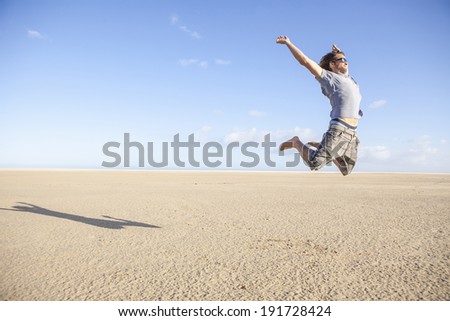 young man jumping happy in the desert