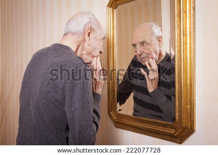 elder man looking at himself at the mirror