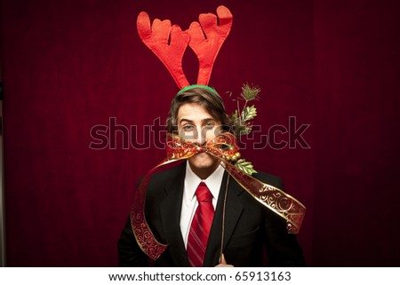 young funny guy with christmas decorations on red velvet background