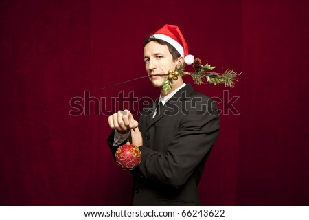 young funny guy with christmas hat on red velvet background