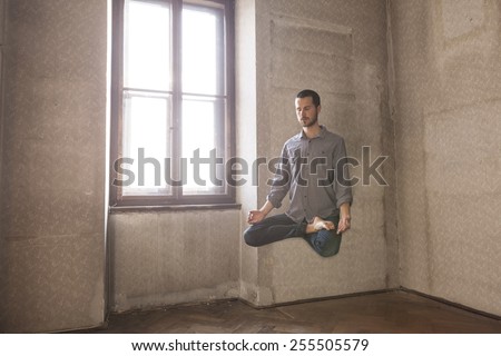 young man levitating in yoga position, meditation
