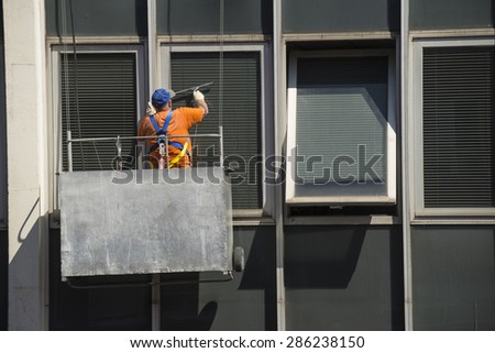WINDOW CLEANER CLEANING WINDOWS IN A BUILDING