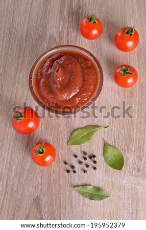 Tomato sauce in a glass gravy boat on a wooden surface