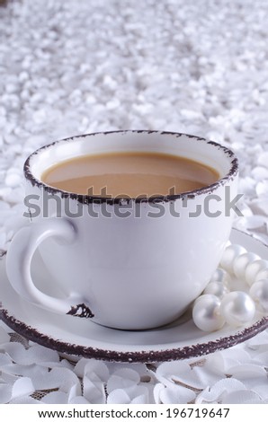 light cup with a drink brown standing on a saucer