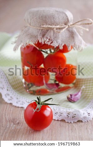 Cherry tomatoes red, lying on a wooden surface background cans of canned tomatoes