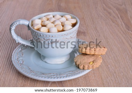 Small marshmallow in a beautiful mug with a dark liquid