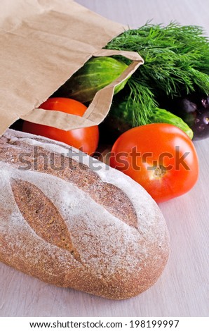fresh bread and different vegetables,lying in a paper bag