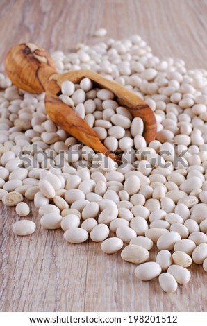 small white beans, sprinkled from a wooden scoop